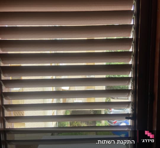 תריסי אלומיניום חומים על חלון